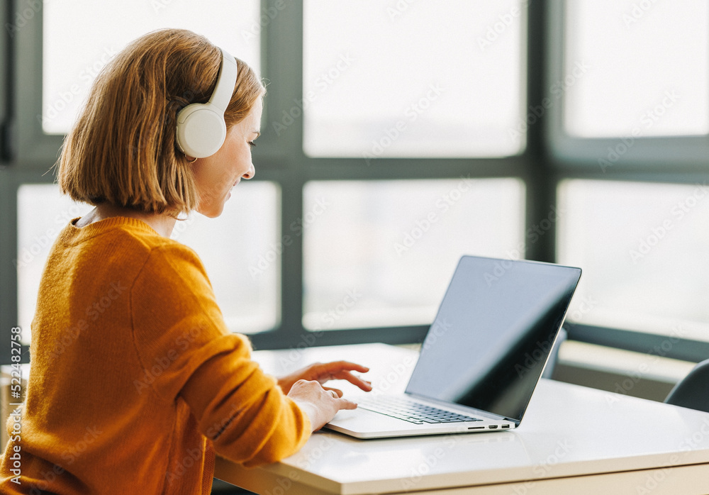 快乐的年轻女性在家远程工作或在笔记本电脑上在线学习时进行视频通话