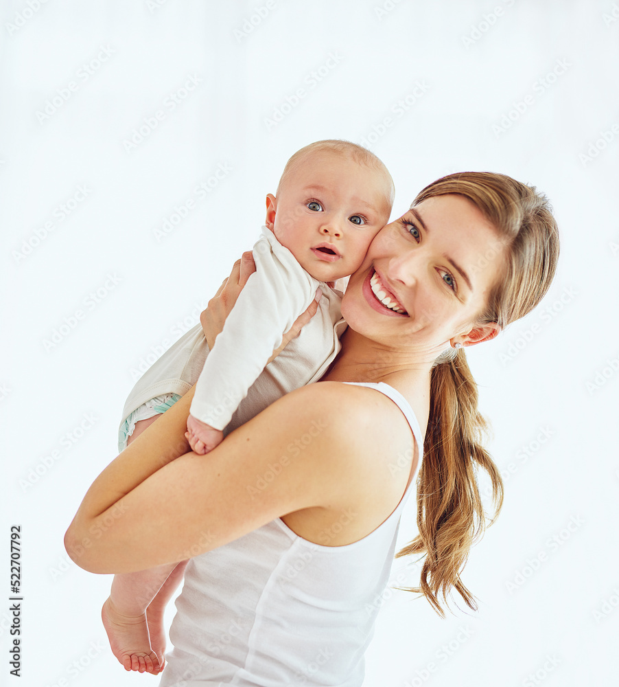 一位快乐的年轻母亲在家里拥抱可爱的男婴，与父母建立联系并享受亲子关系的照片。