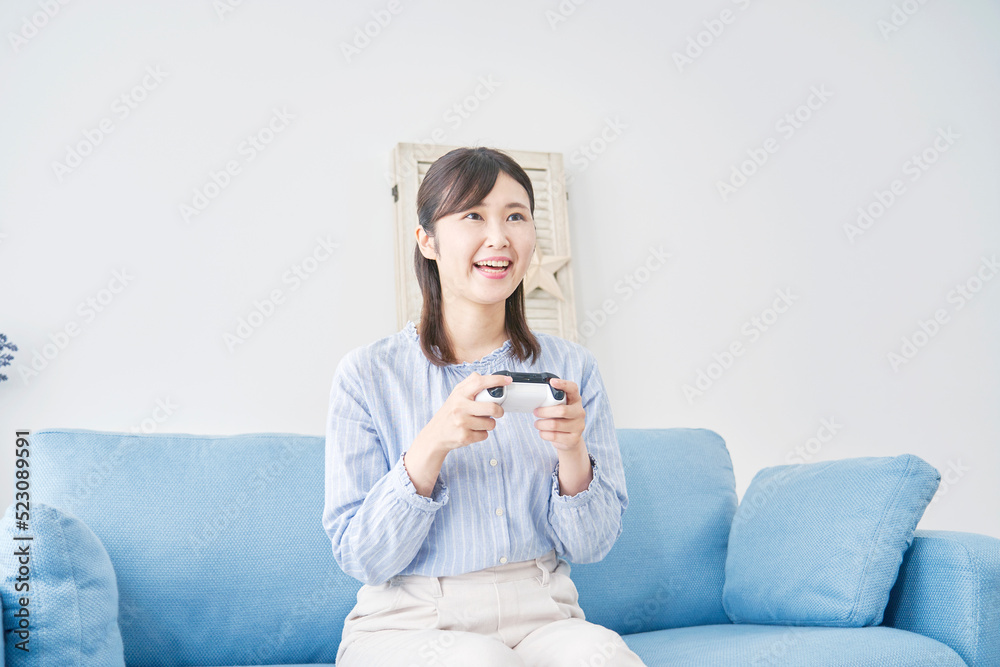  自宅で一人でテレビゲームをする女性