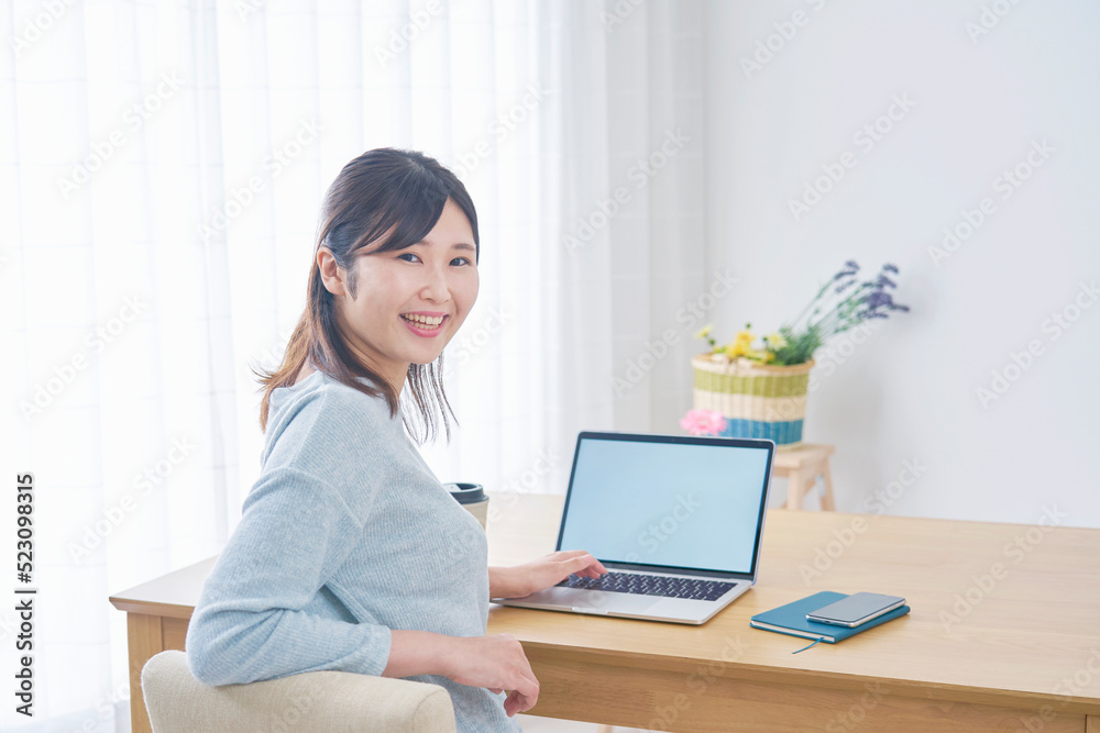 自宅でノートパソコンを使う女性のポートレート
