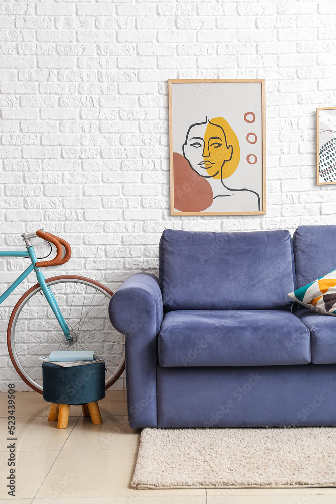 白色砖墙附近的自行车、蓝色沙发和沙发