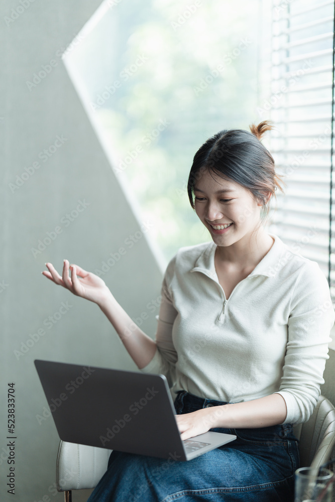 亚洲女人漂亮的年轻女人在办公室用笔记本电脑工作。n在办公室用电脑工作