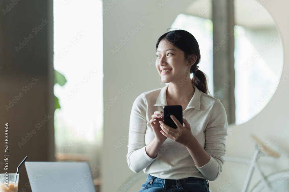 微笑迷人的女人在咖啡馆休息时用手机阅读好消息