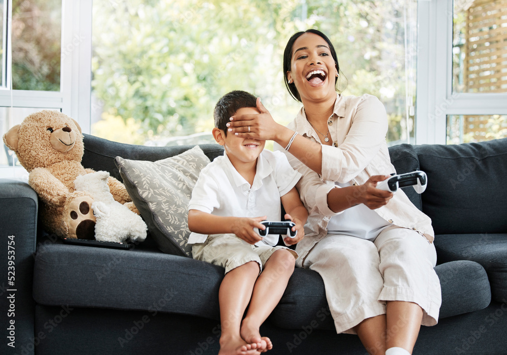 Mother and son playing video games, having fun and enjoying quality time together. Cheerful, bonding