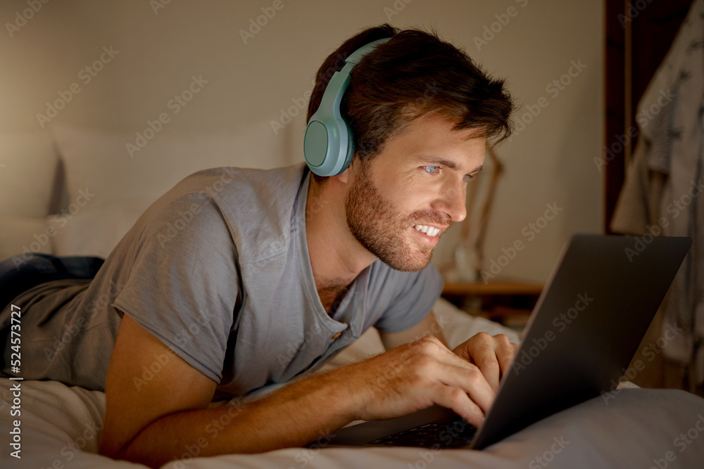 Laptop, video and man streaming a movie in his bedroom on tv via internet while relaxed, smile and e