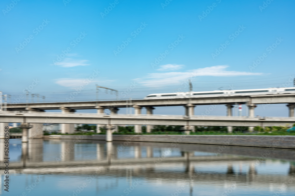 高速列车通过中国现代城市铁路桥