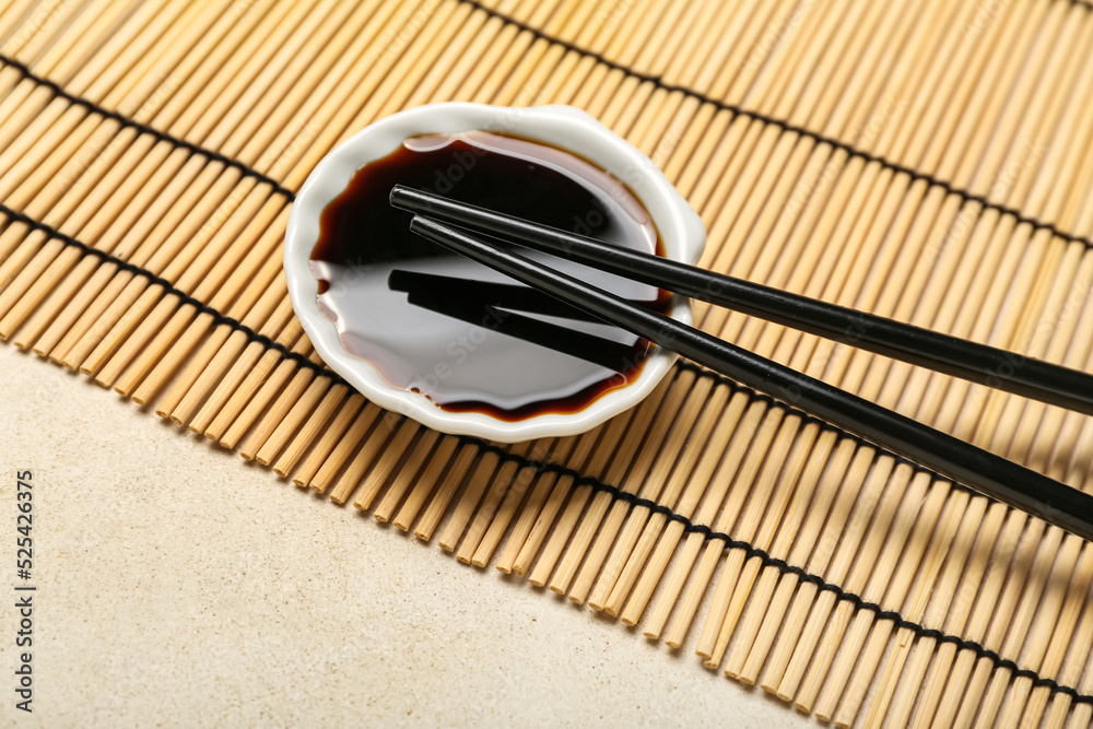 白底一碗酱油、筷子和竹垫，特写