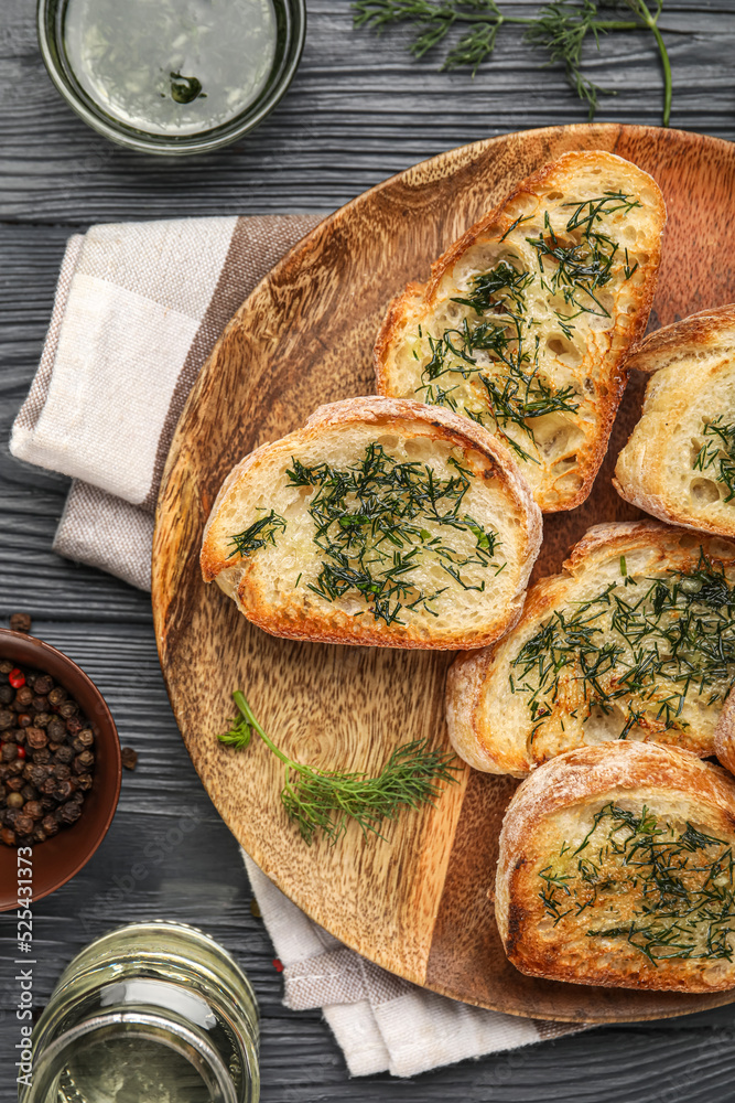 一盘烤面包，深色木质背景，配大蒜和茴香，特写