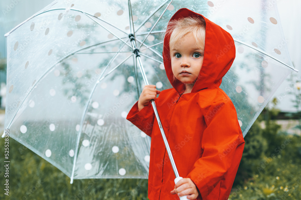 带伞的秋季儿童穿着红色雨衣在户外行走雨天2岁儿童