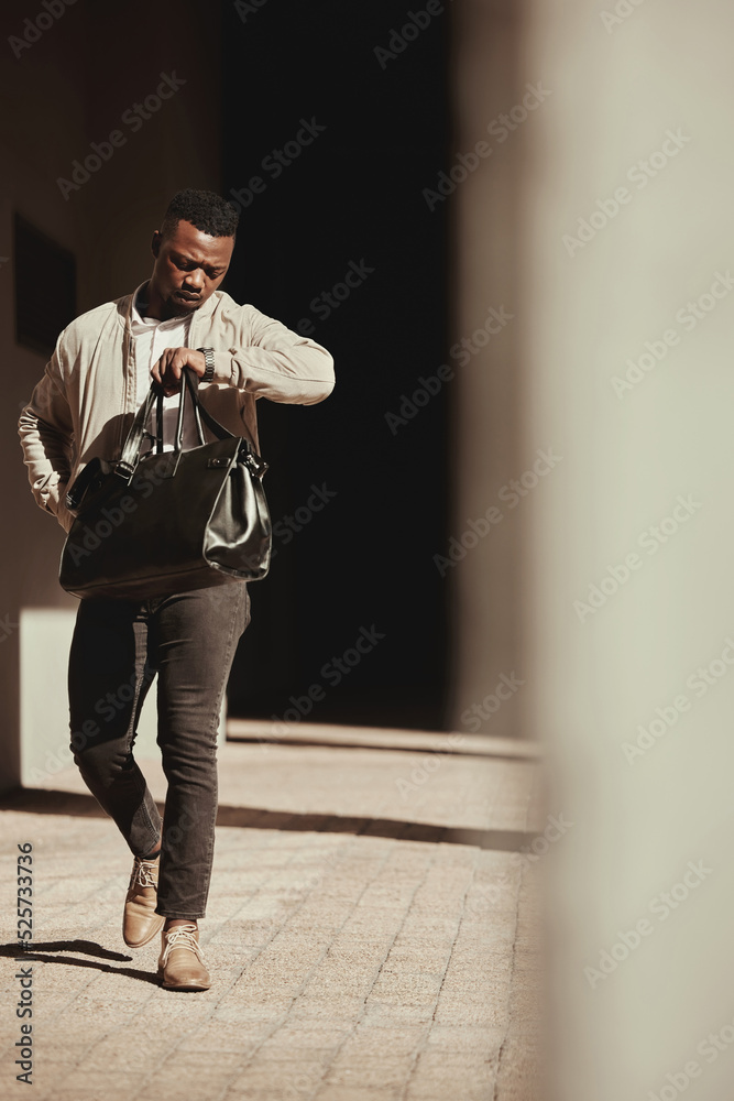 一块手表、一个时间和一个商人在城市里带着一个袋子去参加交易或会议迟到了。忙碌的黑人男性w