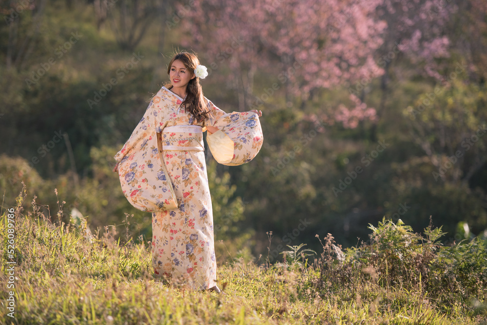 樱花公园里穿着传统日本和服画像的亚洲年轻女子。