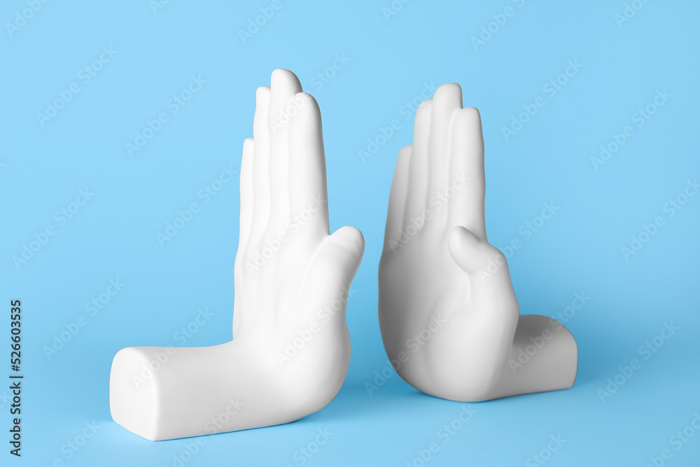 Bookend in shape of hands on blue background