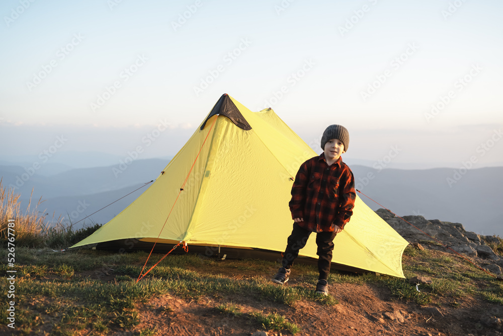 秋山黄色帐篷附近的小孩。带着孩子的概念旅行