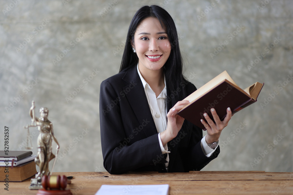 魅力四射的年轻女律师正在读一本法律书，在一家律师事务所的办公桌前工作。