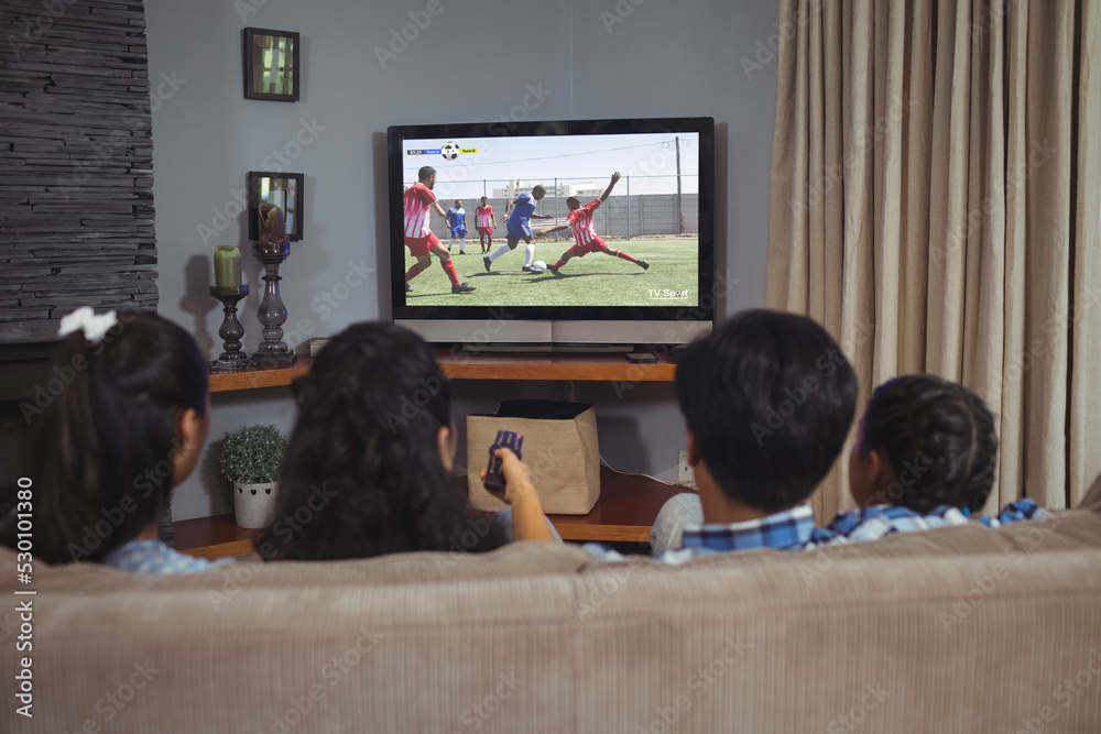 拉丁家庭坐在沙发上用笔记本电脑看足球比赛