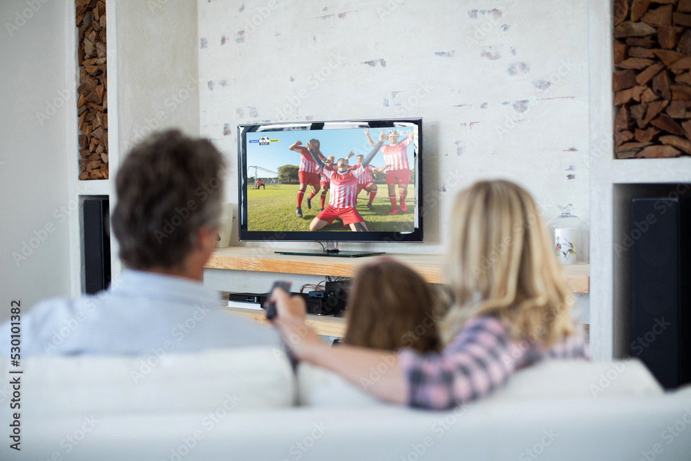 高加索家庭坐在沙发上用笔记本电脑看足球比赛
