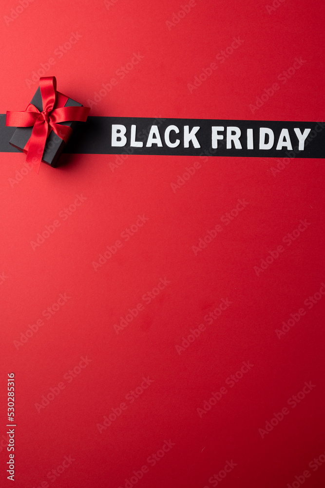 Composition of present with pink ribbon and black friday text on gray and pink background
