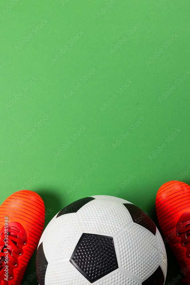 绿色背景下足球和红鞋的构图，带有复制空间