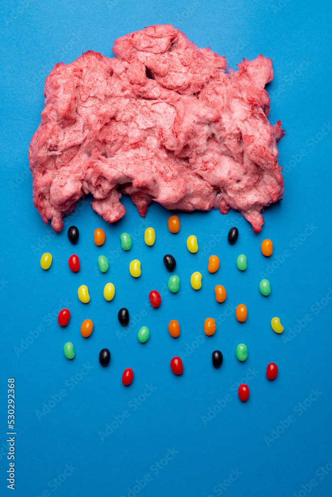 自制粉色牙线的垂直图像，下着果冻豆，蓝色，有复制空间