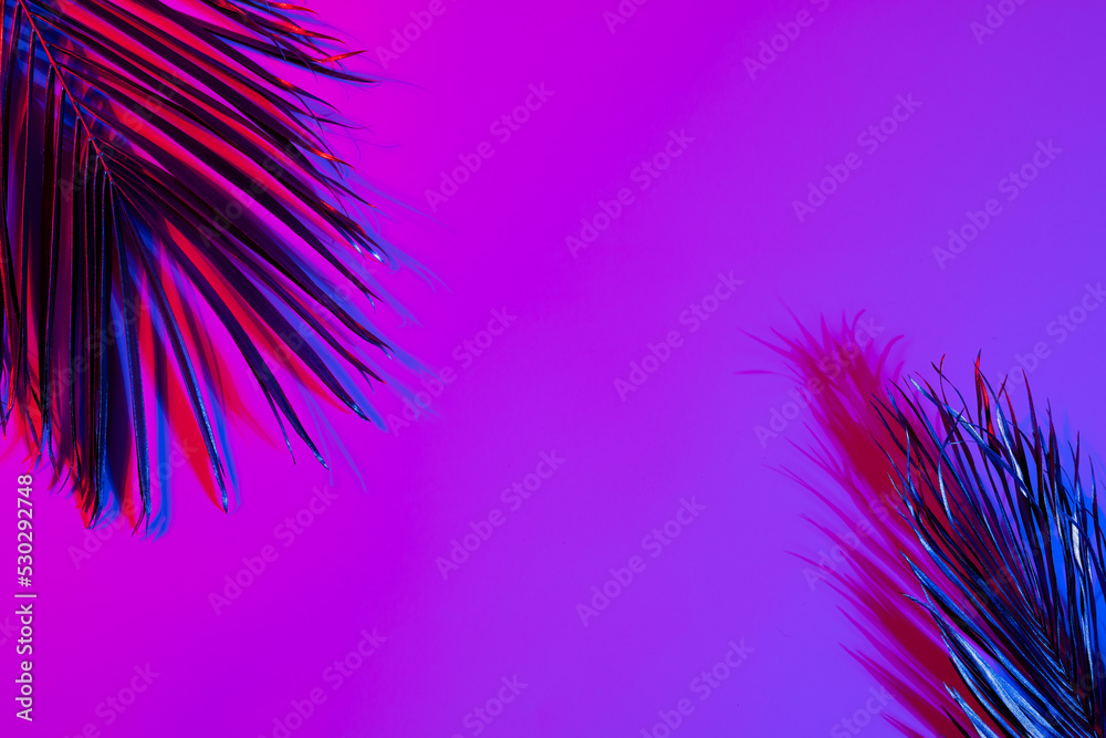 粉红色到紫色背景上充满活力的霓虹灯照亮的粉红色叶子的图像，带有复制空间