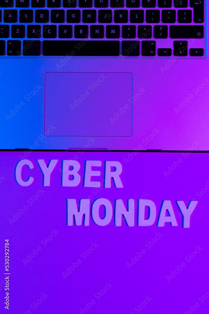 Image of cyber monday text and laptop with copy space over neon purple background
