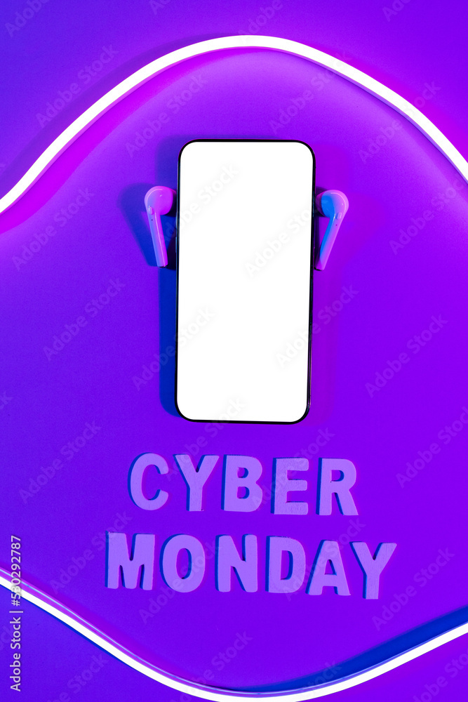Image of cyber monday text, smartphone with copy space and earphones over neon purple background