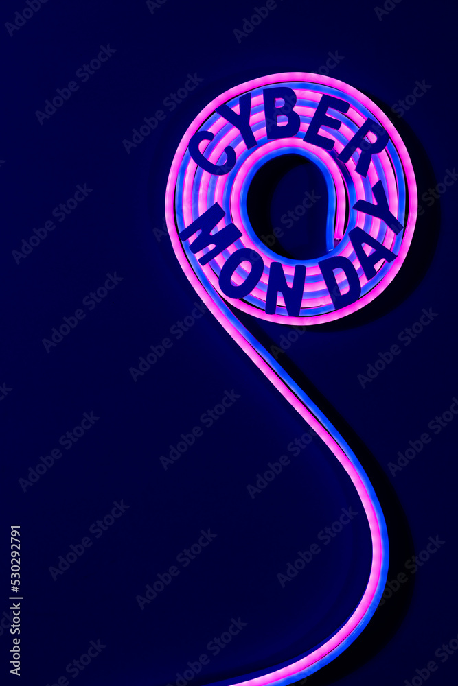 Image of cyber monday text over neon pink and purple glow sticks on blue background and copy space