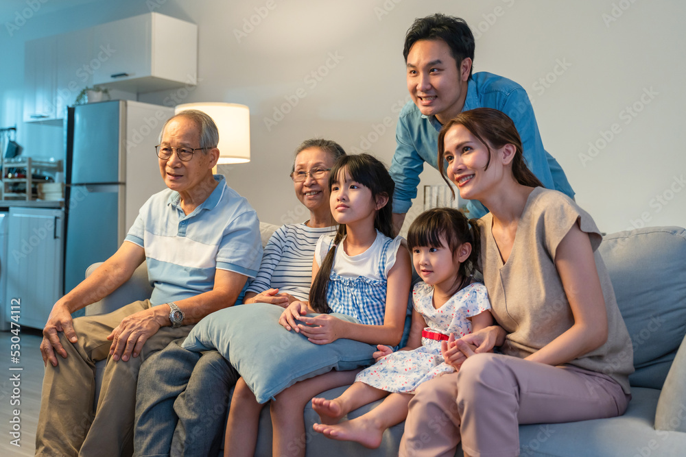 亚洲幸福家庭在家一起看电视上的搞笑电影