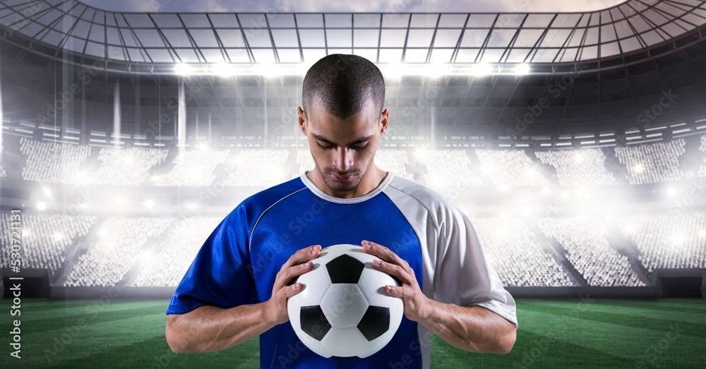 男子足球运动员在体育场上空举足球的构成