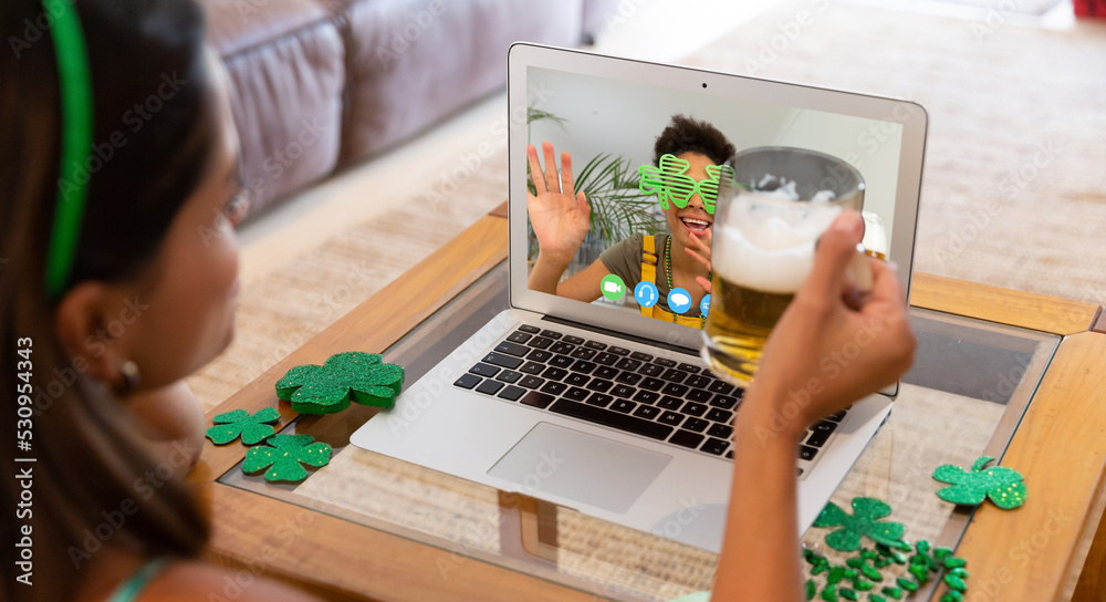高加索女子在家用笔记本电脑视频通话时拿着啤酒
