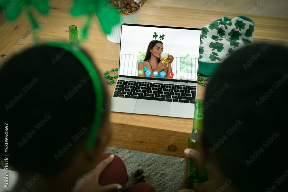 一对非裔美国夫妇在家用笔记本电脑进行视频通话的后视图