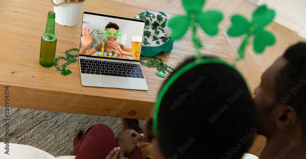 一对非裔美国夫妇在家用笔记本电脑进行视频通话的后视图