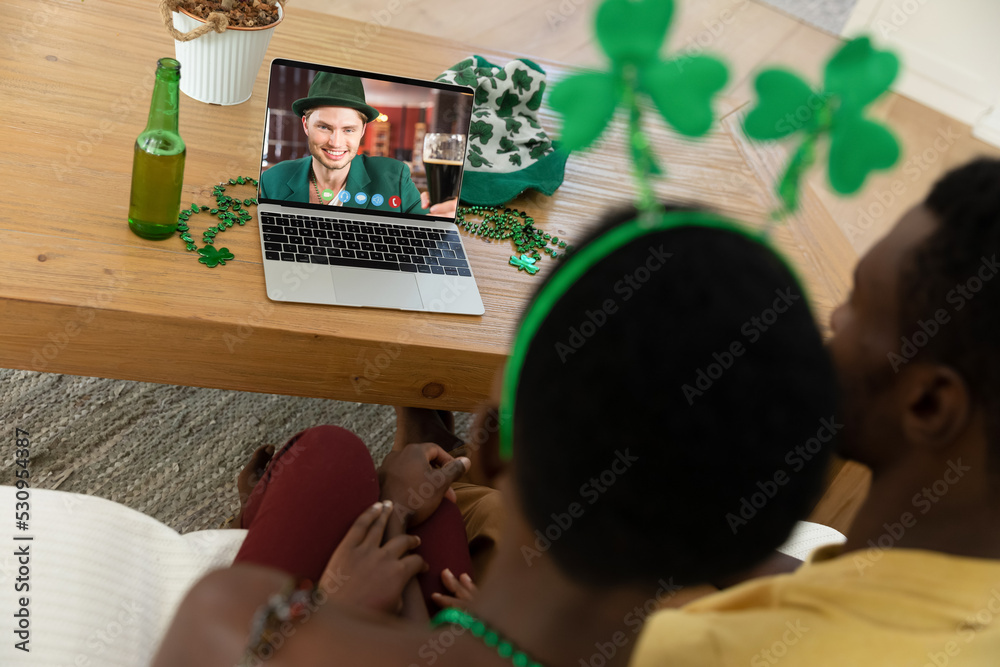 一对非洲裔美国夫妇在家用笔记本电脑进行视频通话的后视图