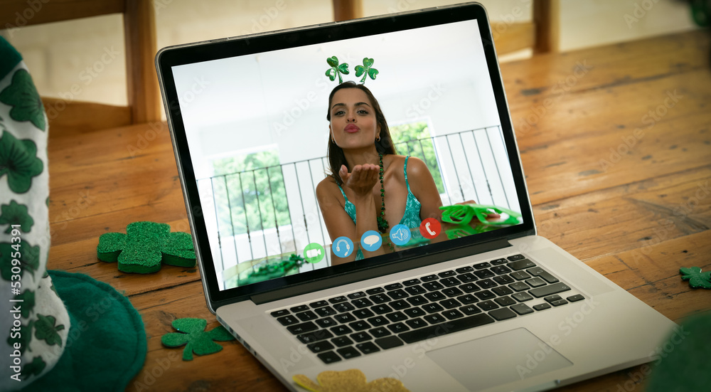 高加索女子在木桌上的笔记本电脑上进行视频通话时飞吻的网络摄像头视图