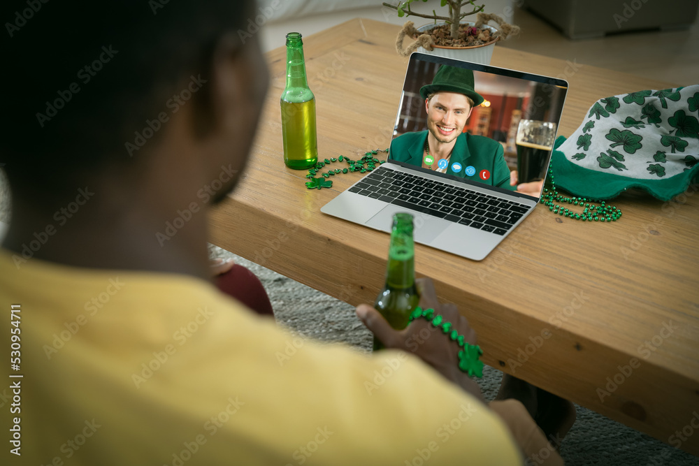 非裔美国人拿着啤酒在家里用笔记本电脑进行视频通话