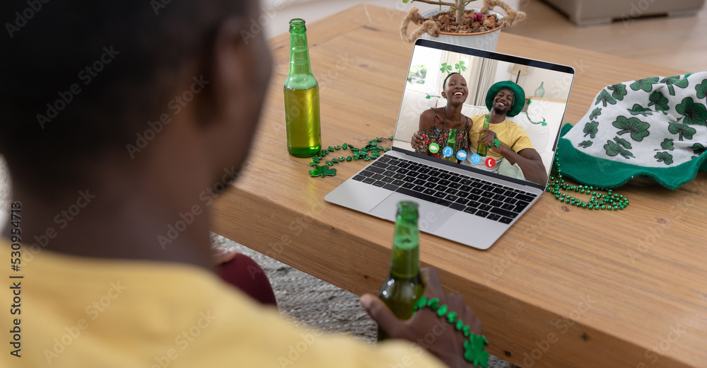 非裔美国人拿着啤酒在家里用笔记本电脑进行视频通话