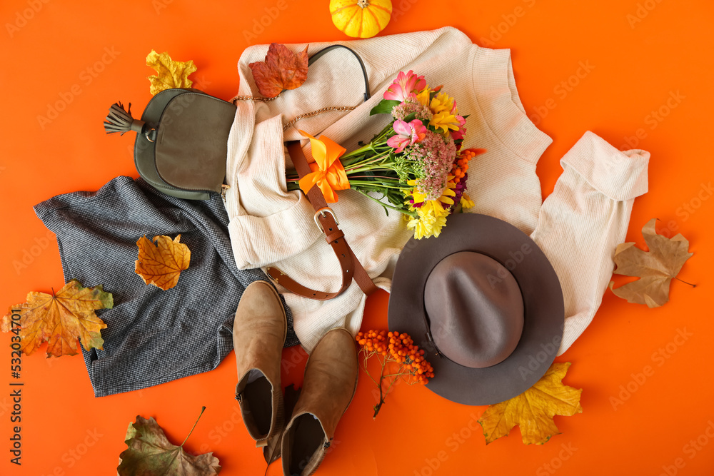 时尚的女性配饰、衣服、橙色背景的花束和秋叶