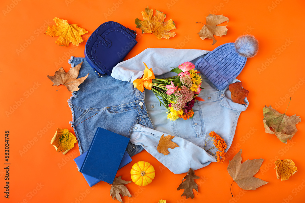 女性牛仔服、配饰橙色背景的花束和秋季装饰