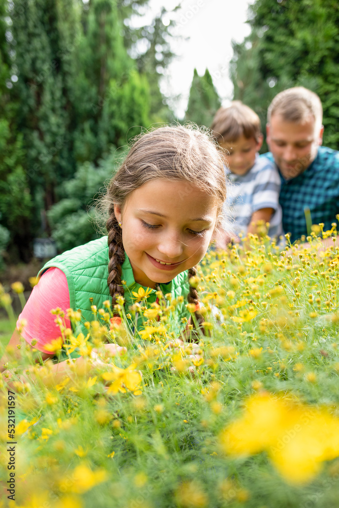 小女孩和家人在后院花园一起照顾植物