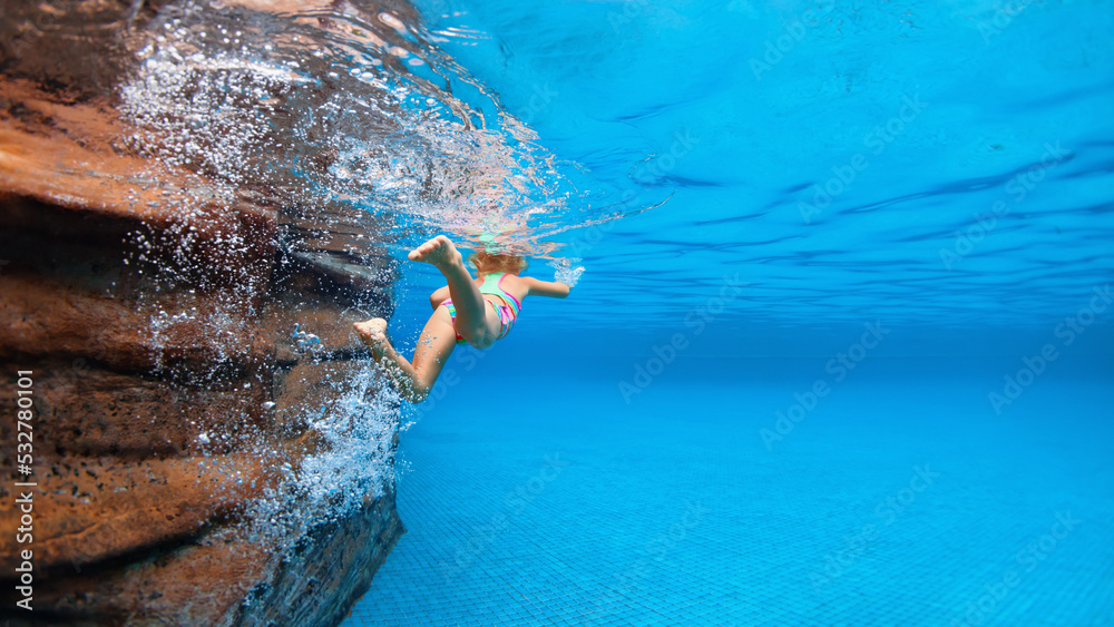 孩子学习游泳的有趣画像，有趣地在蓝色游泳池中潜水——跳到水下深处