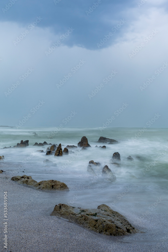 忧郁的天空下的Moody Skulpiesbaai海景，由于长时间的暴露，水和波浪变得模糊