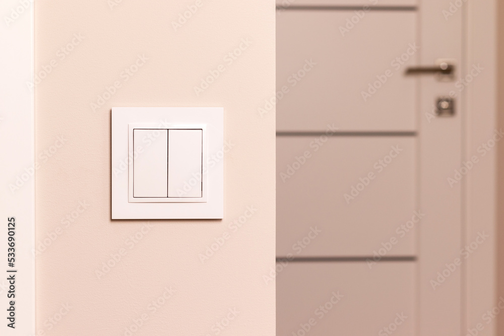 现代公寓门旁米色墙上的白色电气开关