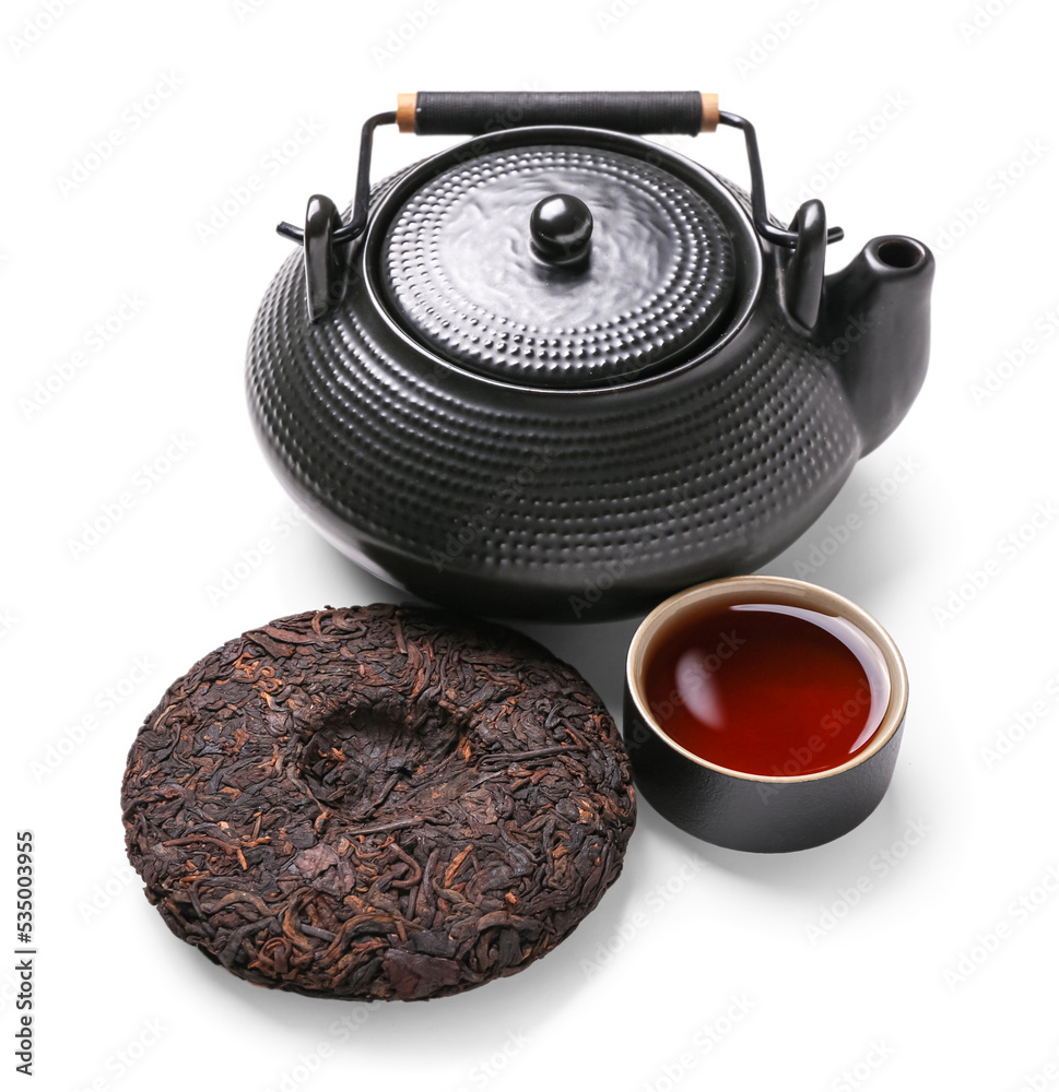 Dry pressed puer tea with cup and teapot on white background