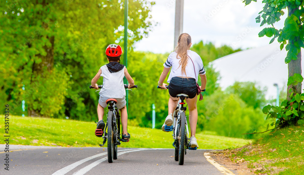 一个男孩和一个女孩在城市公园里骑自行车