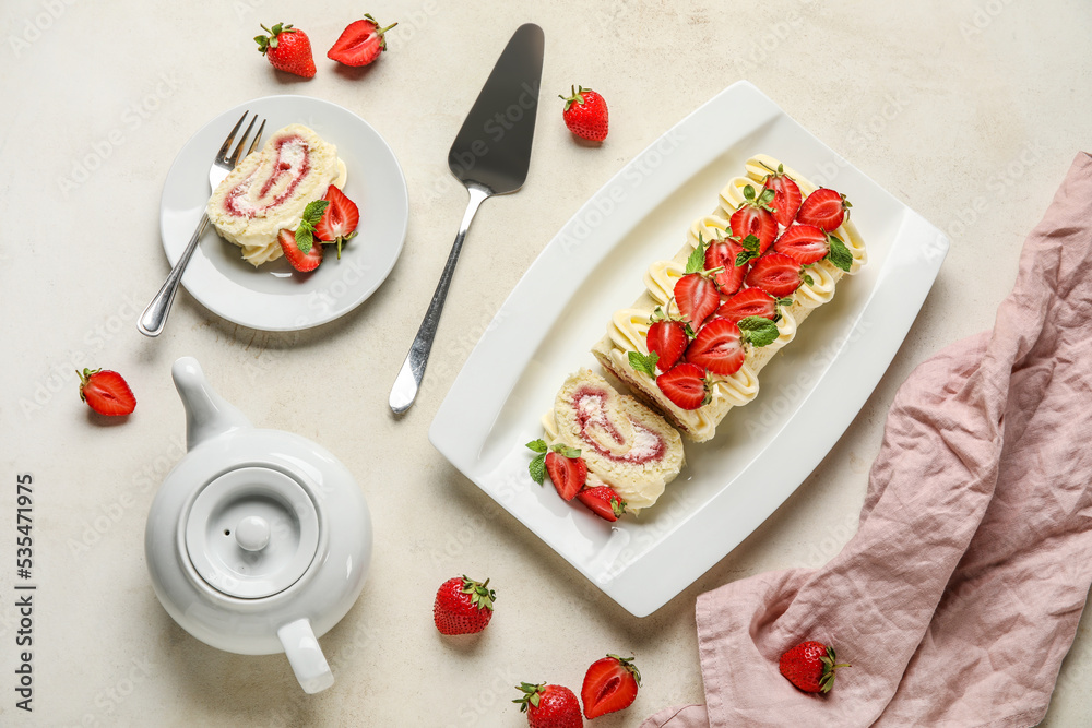 清淡背景下的美味草莓卷蛋糕和茶壶组成