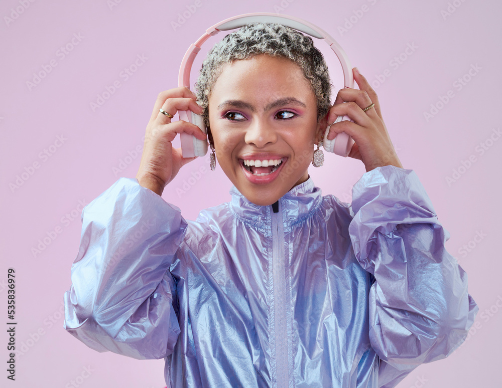 黑人女性，拿着耳机在工作室里欣赏粉色墙壁的音乐流媒体娱乐。Mocku