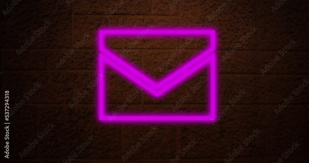 Image of neon email symbol over brick wall
