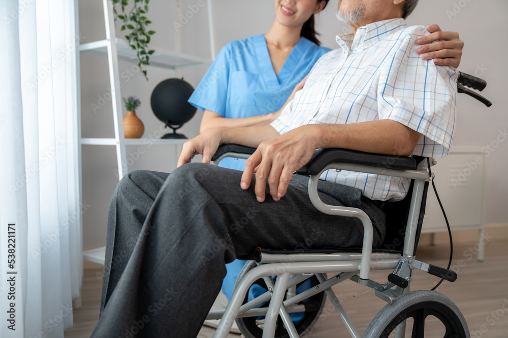 关爱的护士和一个坐在疗养院轮椅上的满足的老人。老年人医疗