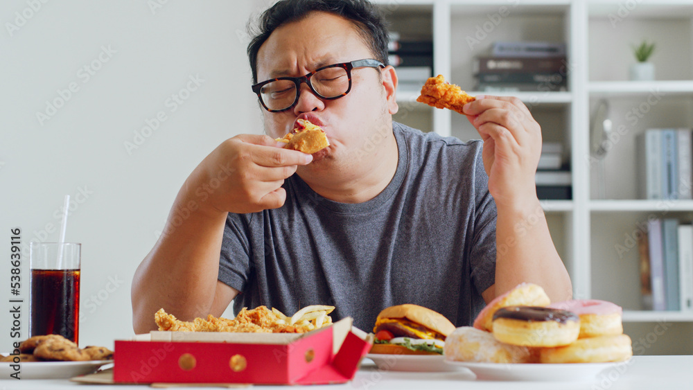 亚洲胖子喜欢吃不健康的垃圾食品、汉堡、披萨、炸鸡