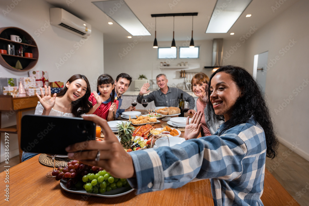 Multi-ethnic family take a selfies while having dinner party in house. 